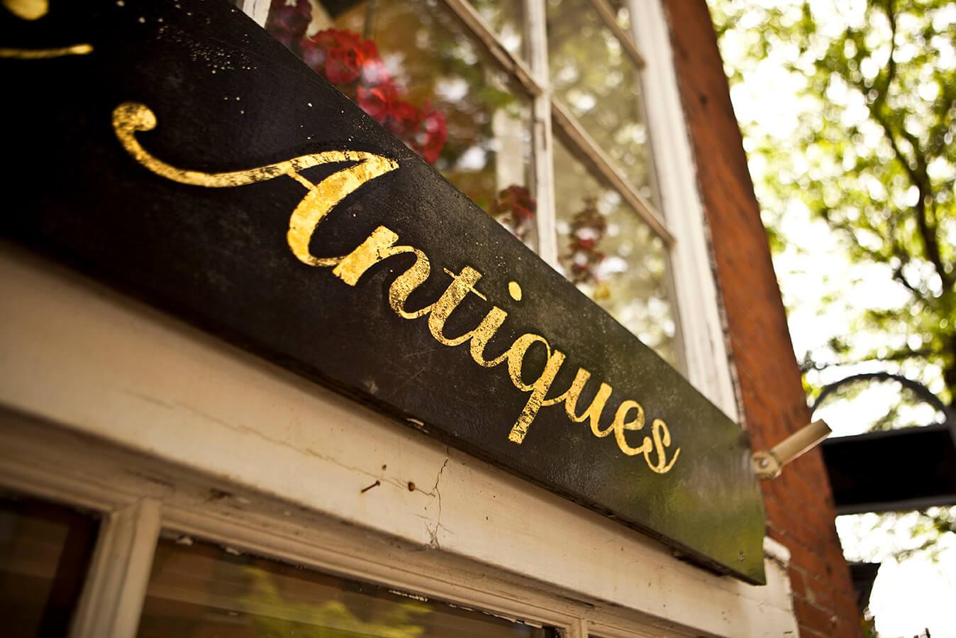 A close up of an 'Antiques' sign