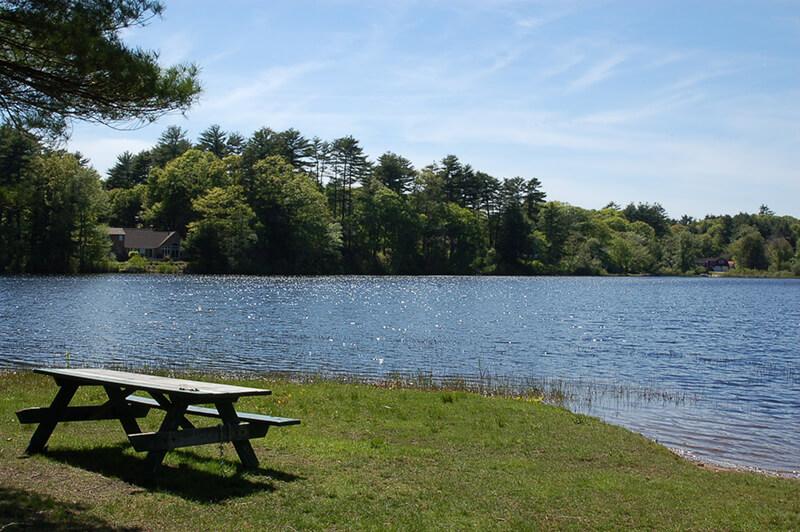 A picnic table next to a lake