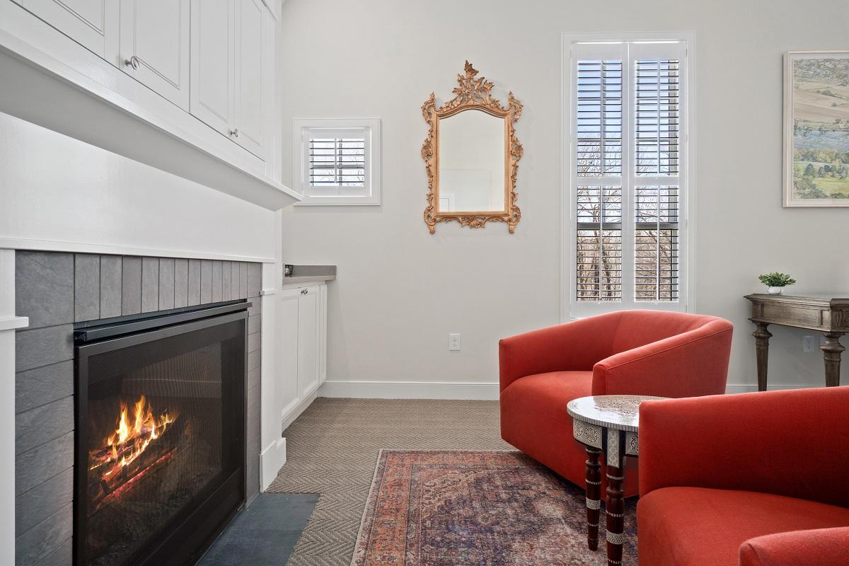 Hotel room chairs pointing towards a fireplace