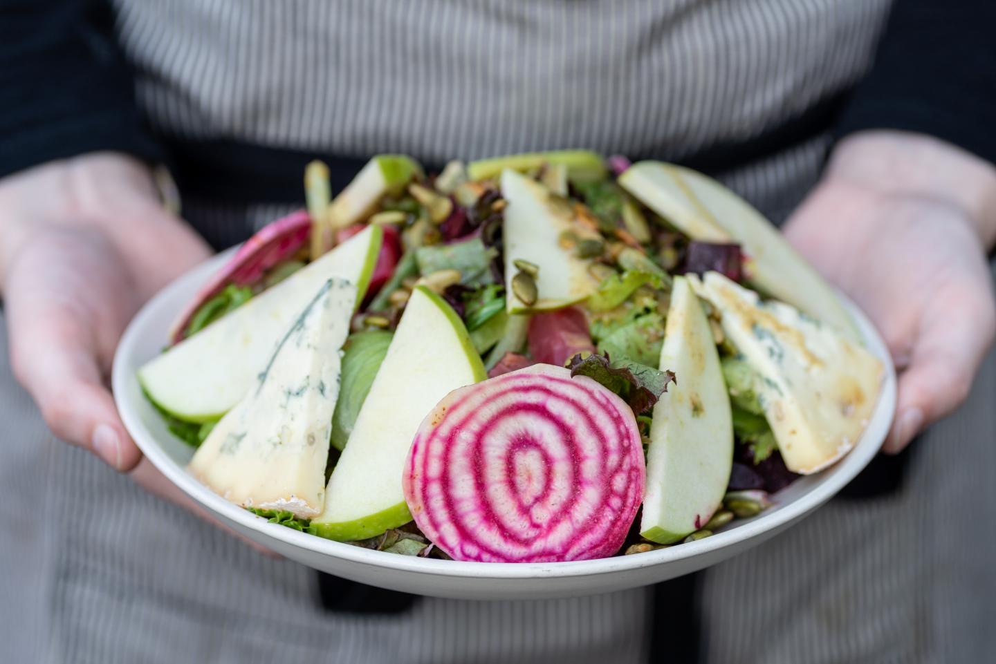 A chef holding a salad