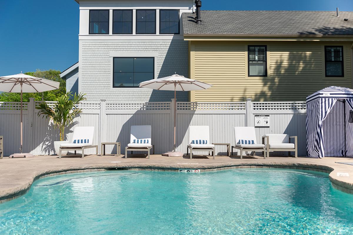 Poolside with loungers and umbrellas under a clear blue sky.