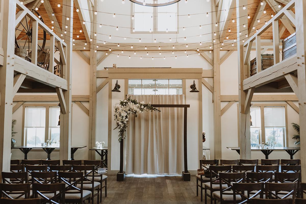 Rustic wedding venue with wooden beams and string lights.