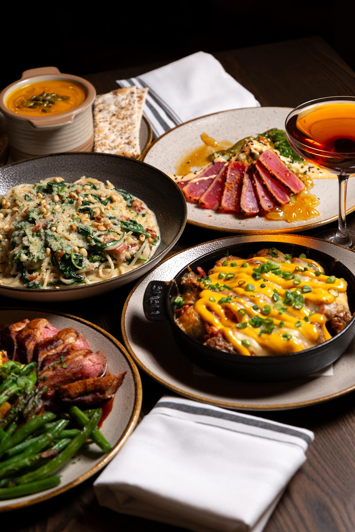 A variety of gourmet dishes including seared tuna, creamy pasta, and cheesy potatoes.
