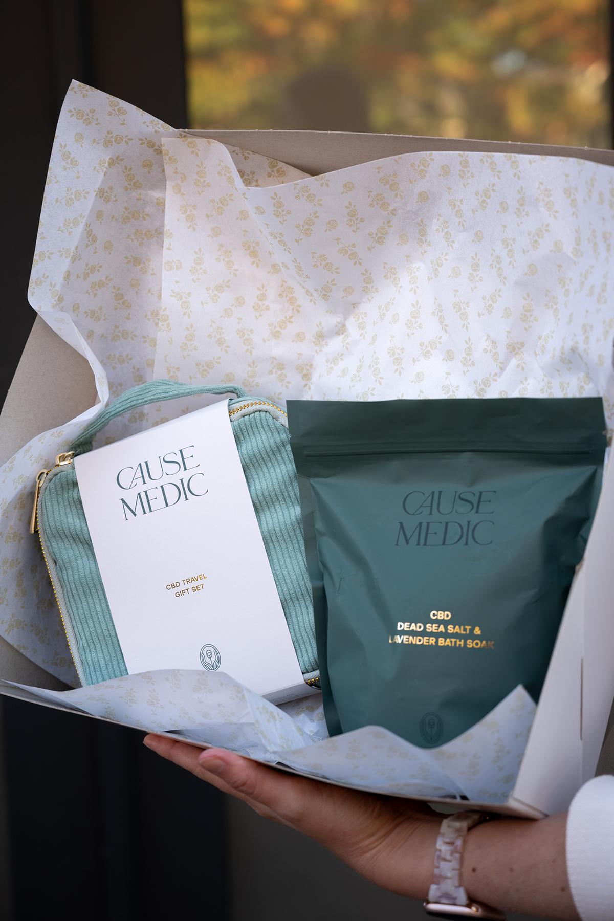 Gift box with teal and white packaging held by a hand.