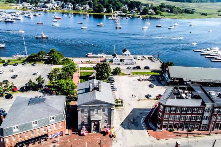 Aerial view of a coastal town with buildings, docks, and boats.