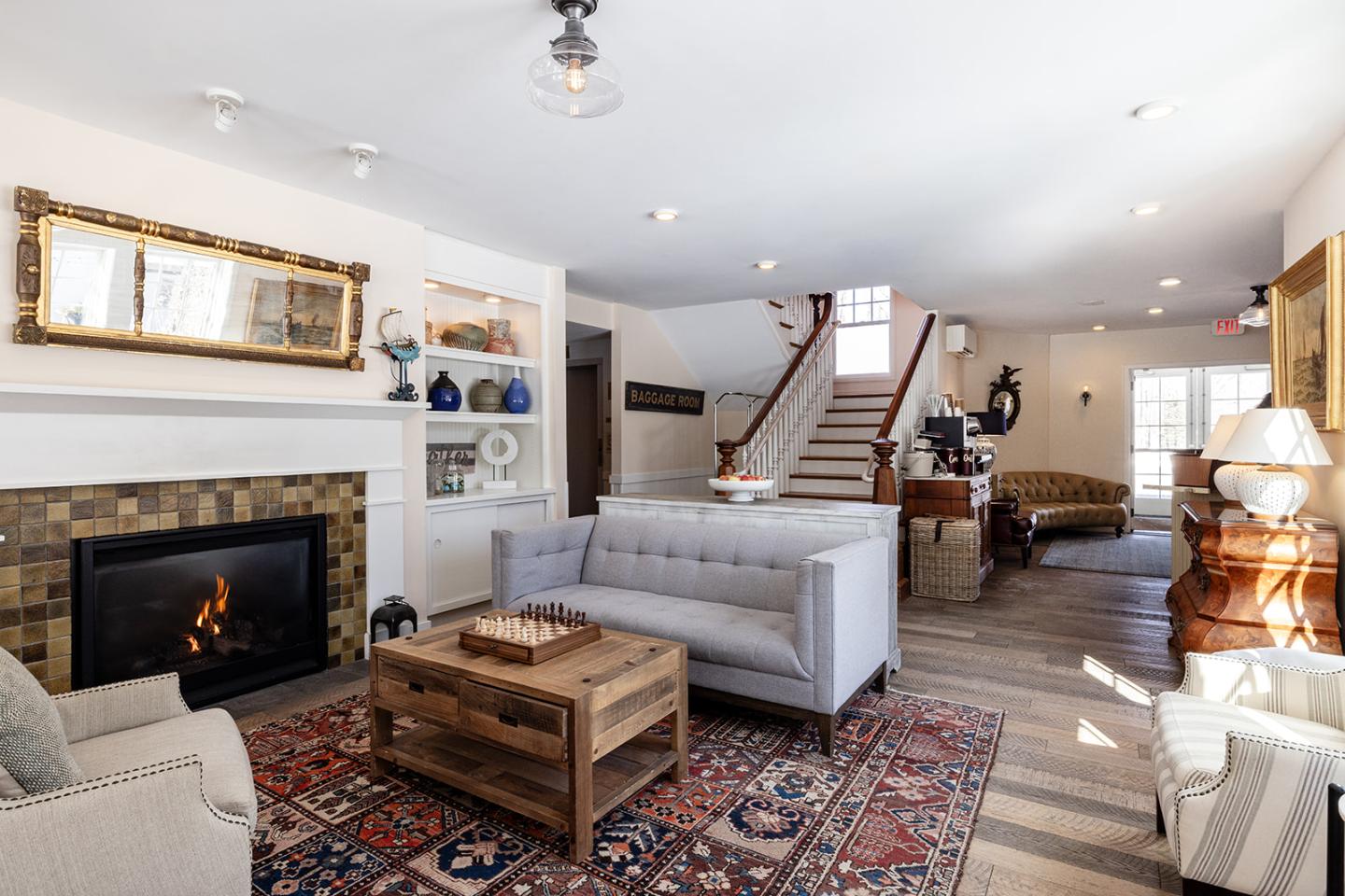 Cozy living room with fireplace, sofas, and staircase.
