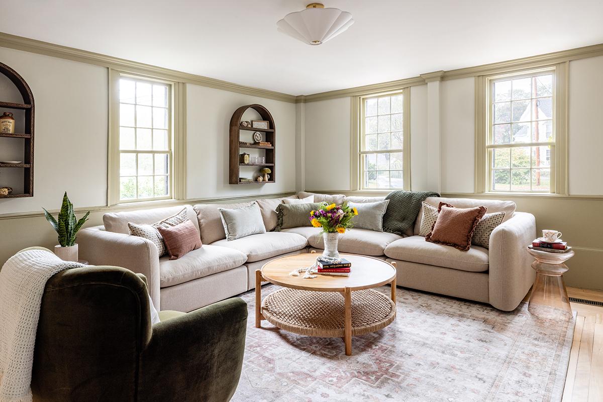 Cozy living room with a beige sectional, green armchair, and round coffee table.