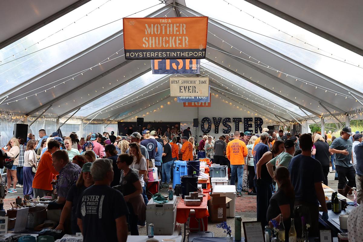 Crowd dining under a white tent at the Nantucket Oyster Festival.