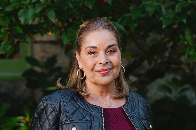 Portrait of a woman in a black leather jacket outdoors.